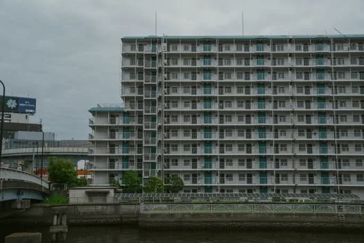 distant apartment complex entrance in Uijeongbu style city street, rainy grey morning, documentary editorial photography, no people, no text