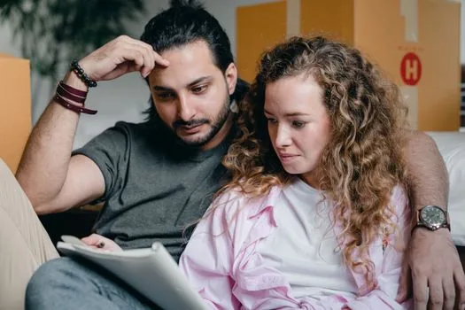 apartment move-in checklist with calendar, transit card, school notice, family reviewing public housing documents at kitchen table