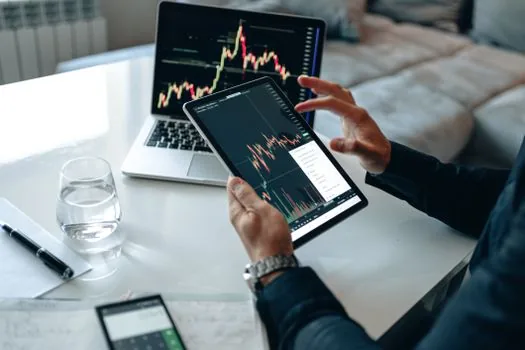 Close-up of hands hesitating over a coffee cup beside a generic stock chart on phone, no readable ticker | 주식 손실 뒤 소비를 줄이는 상황 | 커피값 절약 발언 설명용 이미지