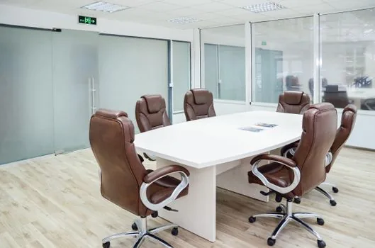 corporate boardroom with empty chairs and legal brief folders, financial newspaper on table, calm documentary news style, no visible brand logos