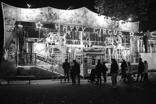 inclusive community event table at an amusement park entrance, families and staff reviewing brochure, warm editorial photography, no readable text or logos