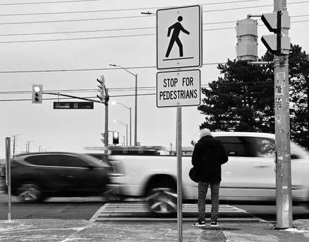 Korean citizen photographing illegally parked car near crosswalk with smartphone, license plate blurred, daylight civic safety scene | 안전신문고 불법주정차 신고 전 차량 위치와 번호판 식별을 확인하는 장면
