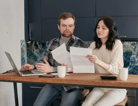 Korean household reviewing old insurance policies and claim notice letters at dining table | 오래된 보험증권과 안내 우편을 함께 확인하는 장면