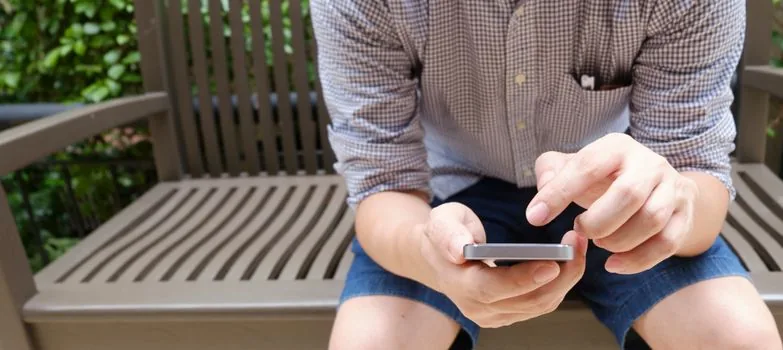 Korean person comparing official insurance website address with suspicious text message on smartphone | 공식 주소와 의심스러운 보험금 안내 문자를 비교하는 장면