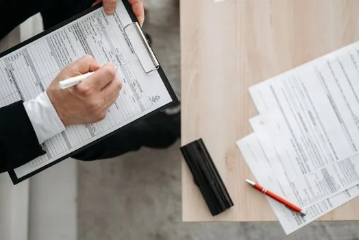 Korean tenant checking lease contract and fixed date stamp at bright apartment desk, realistic editorial photography, no readable personal data