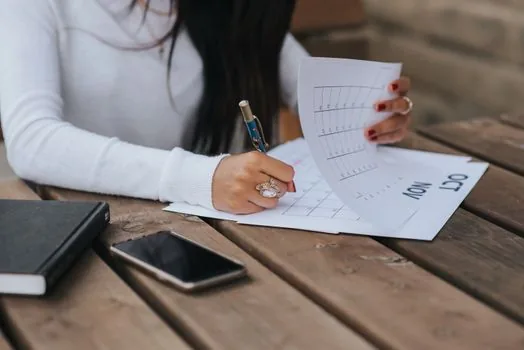 Korean tenant organizing lease contract, moving checklist, calendar, and bank account memo on a small apartment table, realistic editorial photo
