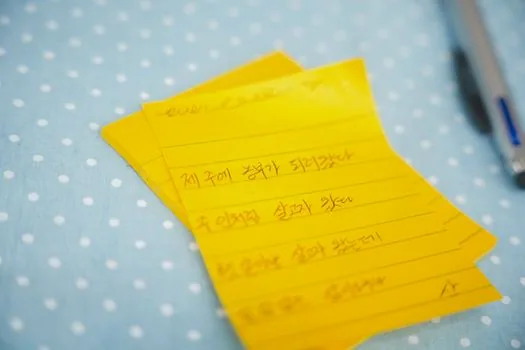 Newsroom editor notes comparing multiple Korean entertainment news reports, laptop and checklist, no readable logos | 보도별 공통 사실을 비교하는 장면 | 출처 교차 확인 설명용 이미지