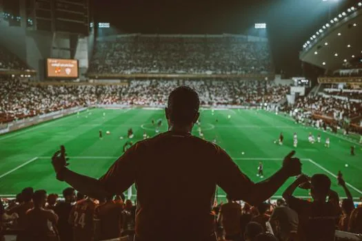 North London football stadium scoreboard showing a clean 3-0 result atmosphere, evening crowd from distance, no readable brand logos, editorial sports photo