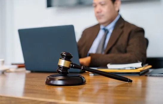 person checking Korean court case number memo beside laptop, legal envelope and calendar on desk, practical documentary style, no readable personal data