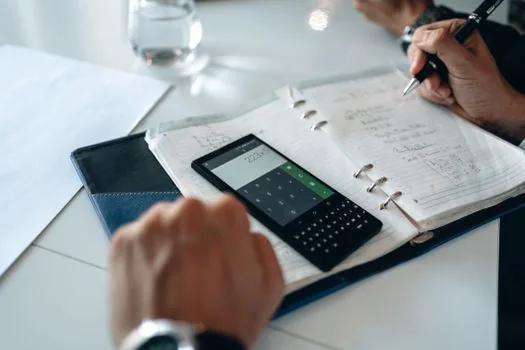 smartphone showing payment schedule checklist beside calculator and utility bill envelope, clean realistic photo without readable private data | 캐시백 지급일정과 계좌 정보를 확인하는 장면