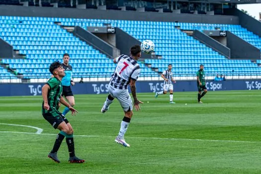 sports editor checking LaLiga league table on laptop, football match photo in background | 라리가 순위표 확인 장면 | 경기 수와 승점을 함께 보는 설명 이미지