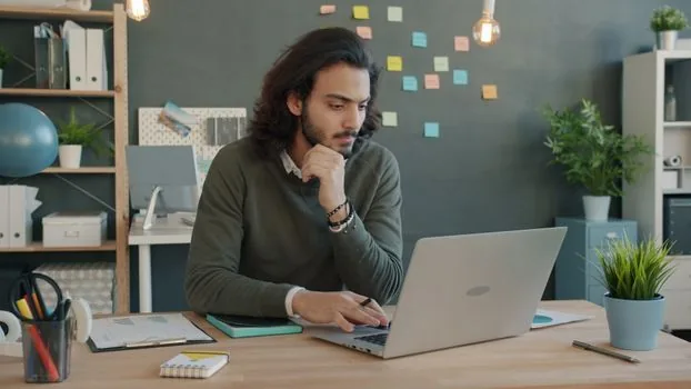 sports editor reviewing live Premier League table on laptop beside match notes and football tactics board, neutral newsroom lighting, no readable brand logos