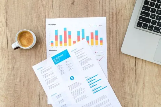 clean spreadsheet with token cost comparison beside terminal window and coffee cup, professional desk scene, no brand names, no private data