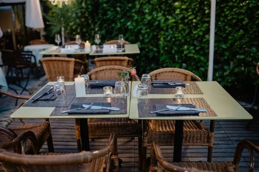 family checking restaurant hygiene rating checklist before dinner reservation, smartphone and notebook on table, clean warm restaurant exterior
