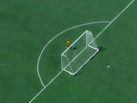 football analyst checking Nations League standings on laptop, match notes, green pitch on TV in background | 네이션스리그 A4조 순위를 확인하는 스포츠 편집 장면