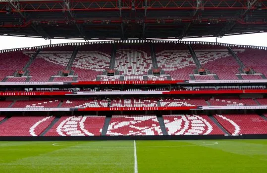 football calendar board with next European fixtures, stadium lights, analyst notes, no copyrighted crests, neutral sports newsroom