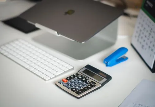 Korean government gazette asset disclosure page on monitor with calculator and highlighted numbers on desk | 공직자 재산공개 숫자를 확인하는 편집 장면