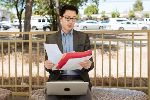 Korean job applicant reviewing hiring documents and public service login on laptop, no readable personal data, realistic editorial photo