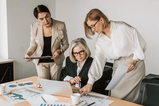 Korean small business team meeting with senior advisor, whiteboard strategy map, laptop, practical consulting mood | 중소기업 팀이 외부 전문가와 프로젝트 방향을 논의하는 장면