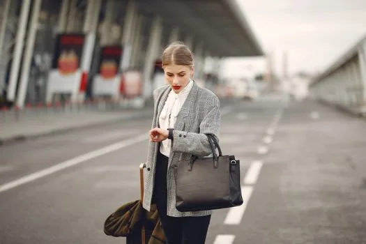 Korean traveler checking Incheon airport real-time departure hall waiting time on smartphone beside suitcase in airport train station, realistic editorial photo, no readable private data | 공항으로 이동하기 전 출국장 대기시간을 확인하는 장면