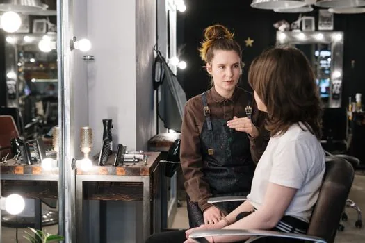 parent reviewing teen haircut result in a clean Korean hair salon, neutral documentary style, no identifiable face, no logo