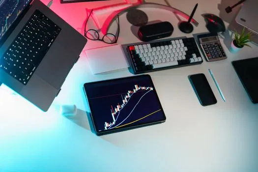 smartphone crypto news alerts beside laptop market chart in Korean newsroom, no real exchange logos, editorial photography