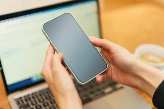 smartphone showing abstract social media account status checklist, laptop open to official help center, Korean newsroom desk, no logos, realistic photo | 계정 상태 화면과 공식 도움말을 함께 확인하는 장면
