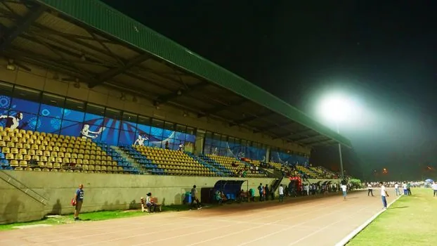 smartphone showing Asian Games schedule checklist with stadium lights in background, practical sports information image